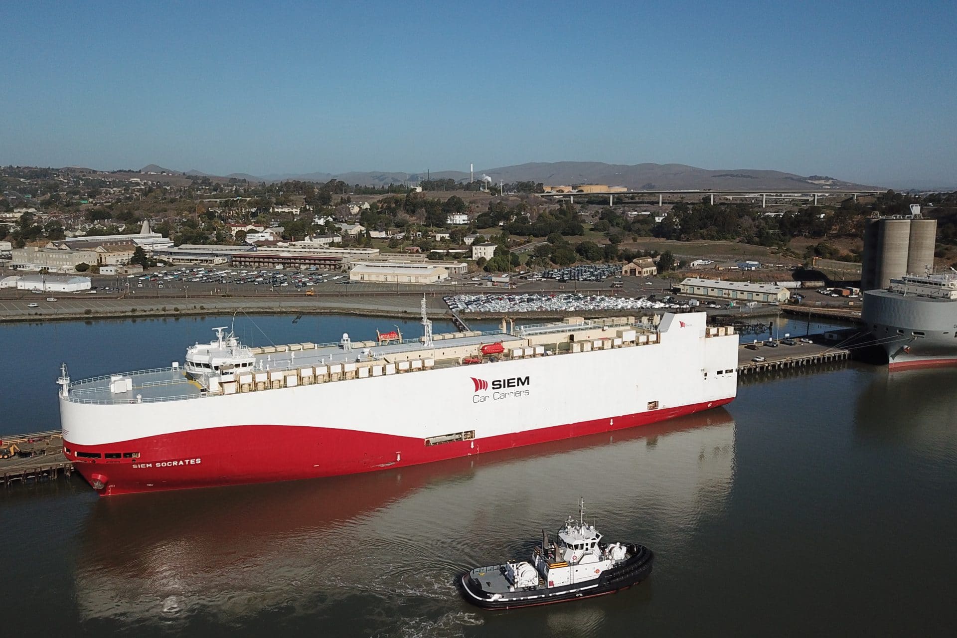 Small boat passes ship at harbour